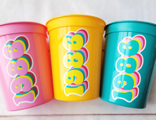 Best of 1986 retro 40th birthday party cups in pink, yellow, and teal with layered vintage typography design