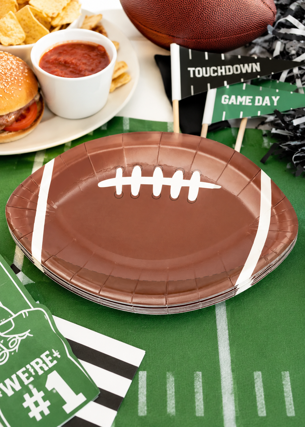 Football shaped brown paper plates for game day parties and tailgate celebrations
