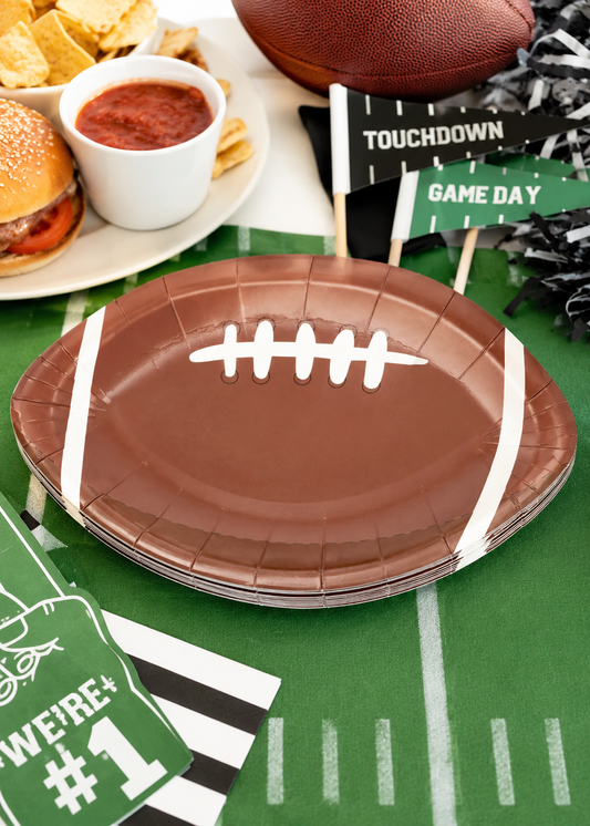 Football shaped brown paper plates for game day parties and tailgate celebrations