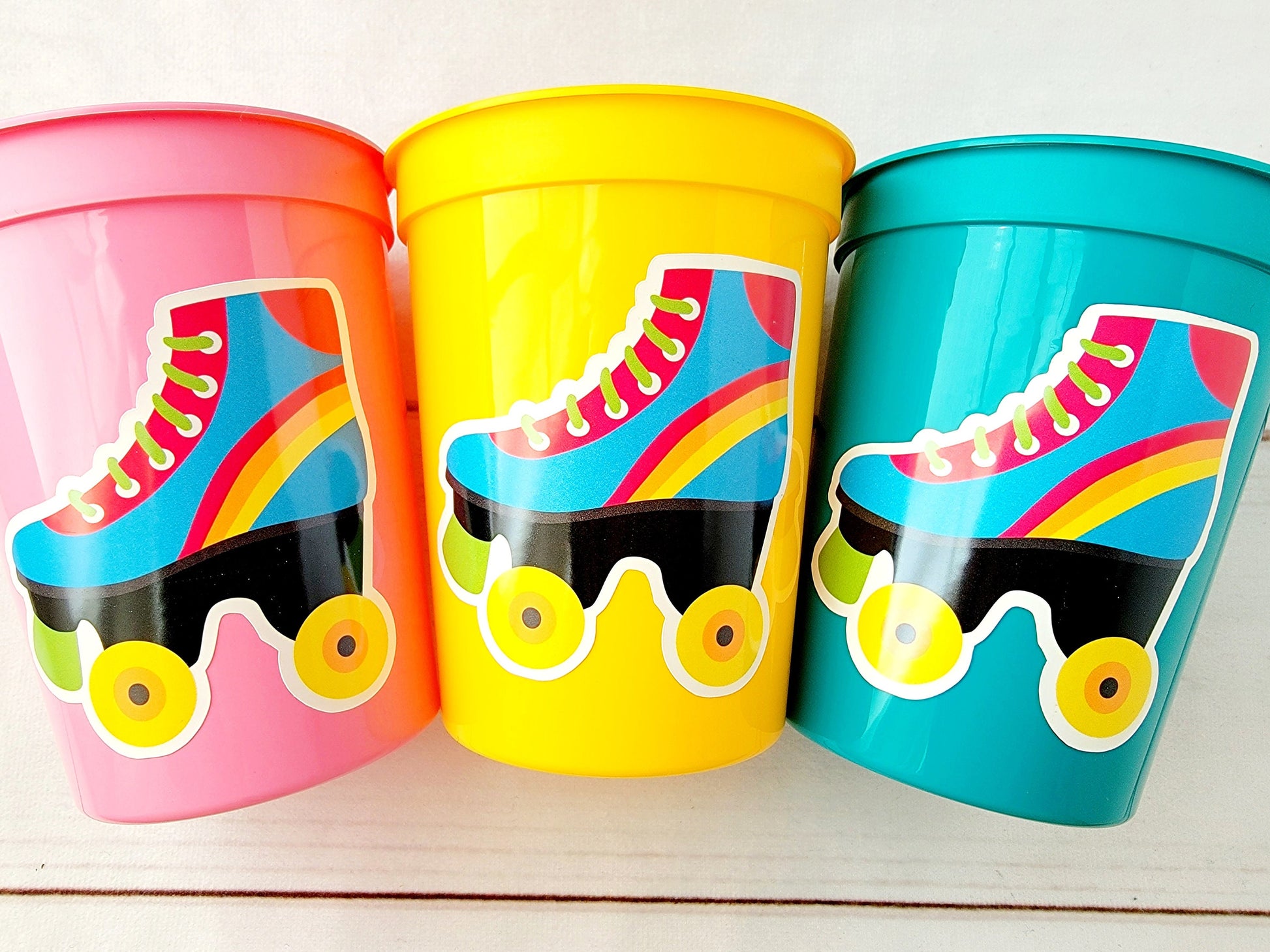 ROLLER SKATE PARTY Cups - Roller Skating Birthday Cups Skate Party Favors Skating Party Cups Roller Skating Birthday 80's Birthday Party

May include: Three plastic cups with roller skate designs. The cups are pink, yellow, and teal. Each cup has a sticker of a blue roller skate with a rainbow stripe and black wheels. The roller skate has a green lace and a yellow tongue.