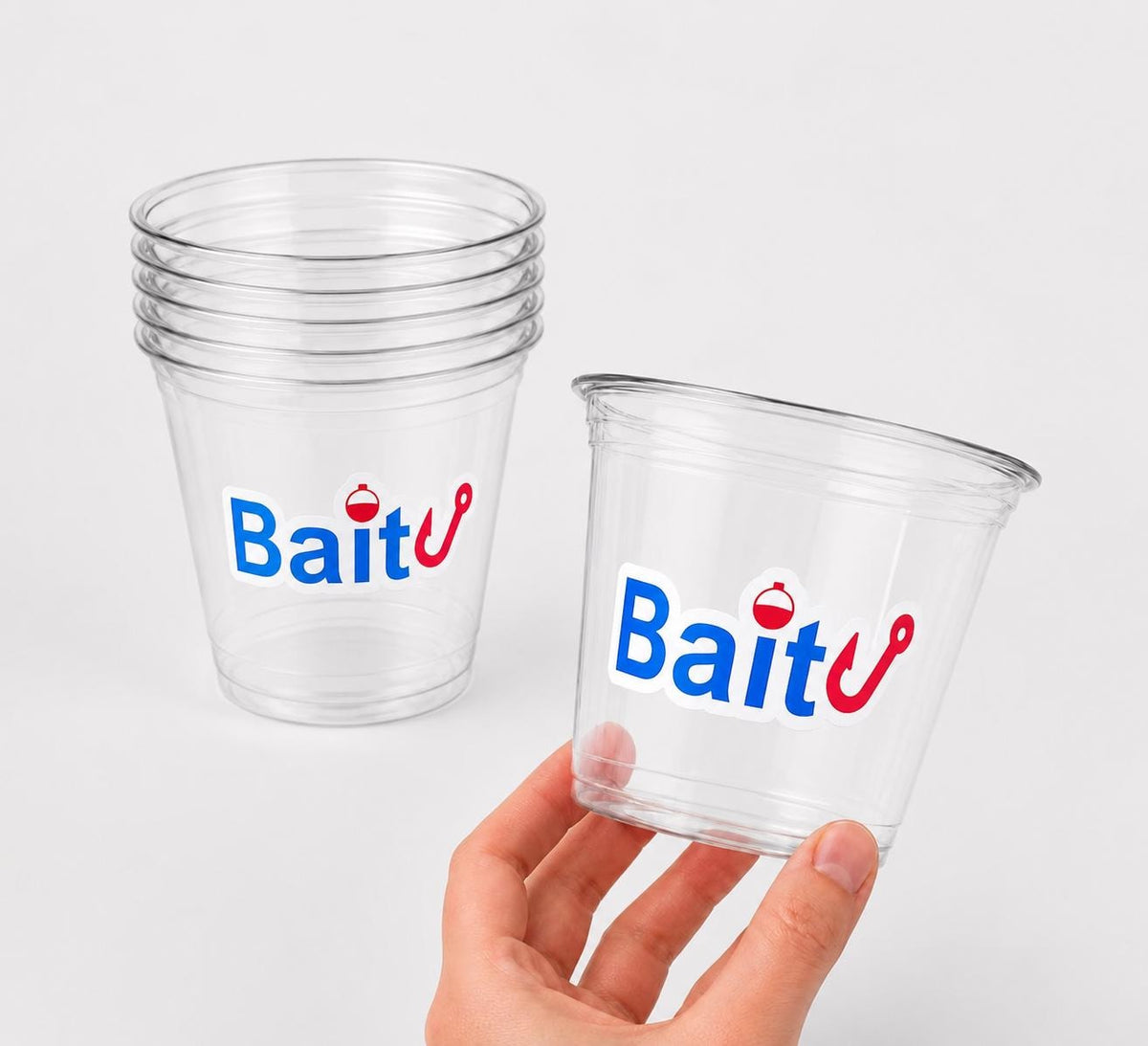 May include: Clear plastic cups with the word "Bait" in blue and red lettering. One cup is held by a hand. The cups are stacked in a pile of five. The logo includes a fishing hook and a bobber.